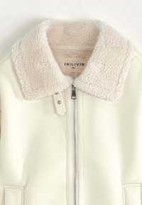 Veste en cuir synthétique crème avec un col en fausse fourrure beige doux. Comprend une fermeture éclair à l'avant et des poches latérales ; contient une étiquette de la marque à l'intérieur.