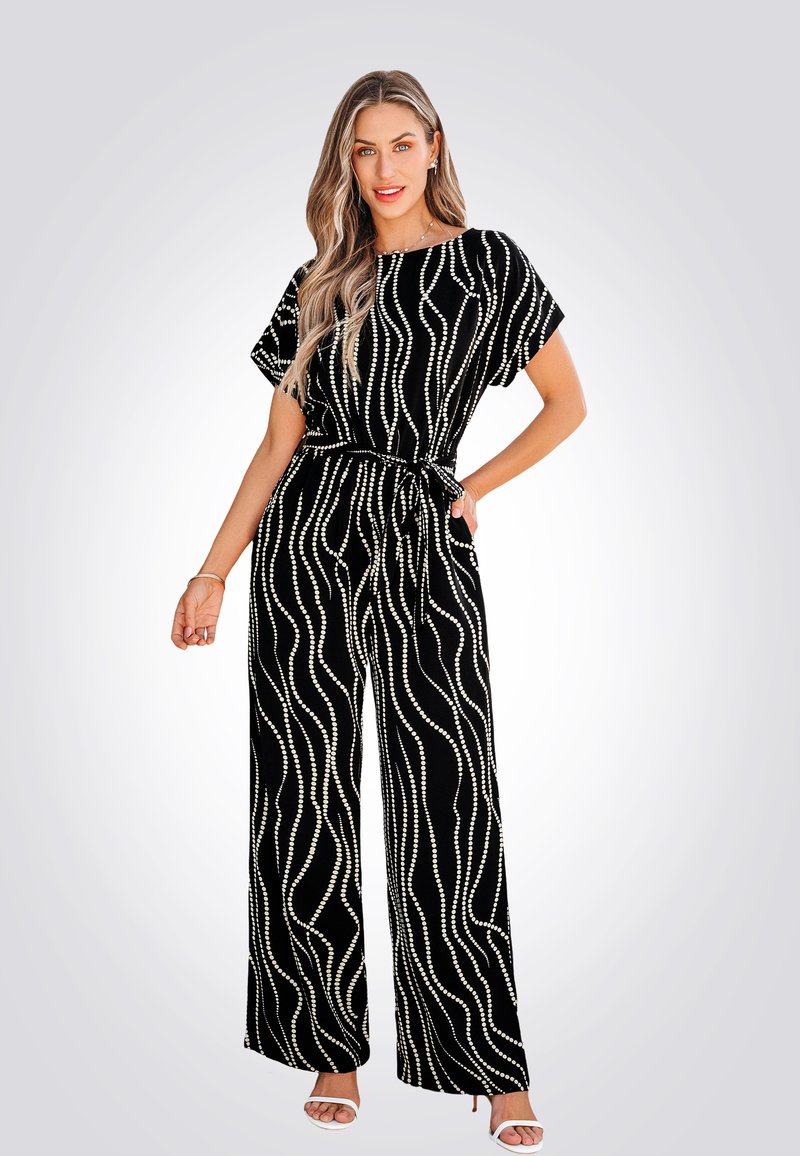 Combinaison ample noire à jambes larges avec des lignes ondulées blanches, manches courtes et ceinture à nouer. Fabriquée dans un matériau doux avec une texture lisse.