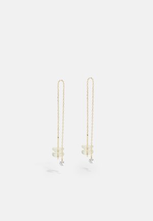 Pendientes de cadena de oro con acentos circulares transparentes y una pequeña gema clara al final, que muestran un diseño delicado.