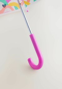 Rózsaszín műanyag markolata egy ívelt esernyőhorgatnak, egy fényes ezüst fém tengelyhez rögzítve, világos háttér előtt.