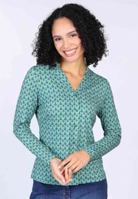 Langärmlige grüne Bluse mit einem sich wiederholenden blauen und roten Paisleymuster, ausgestattet mit einem V-Ausschnitt und Knopfdetails. Glatte Stoffstruktur.