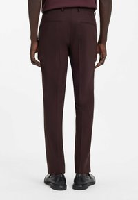 Dunkelburgunderrote, maßgeschneiderte Hose mit glatter Textur, schmaler Passform und Taschen-Details, kombiniert mit schwarzen Anzugschuhen.