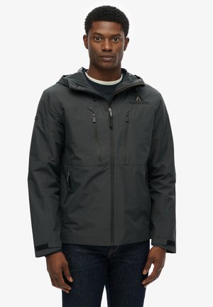 Dunkelgraue wasserdichte Jacke mit Kapuze, ausgestattet mit zwei Reißverschlussbrusttaschen, seitlichen Taschen und verstellbaren Bündchen. Glatte Außenstruktur.