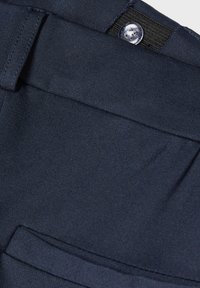 Marineblauwe broek van een gladde stof, met een voorzak en een knoopsluiting aan de taille met een gestructureerde tailleband.