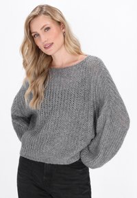 Maglione grigio lavorato a maglia con una forma ampia e squadrata, texture a costine e maniche larghe. Presenta un tessuto a trama aperta e un collo rotondo.