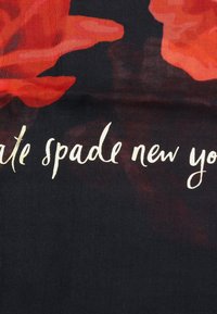 Schwarzer Stoff mit großen roten Blumenmustern, auf dem "kate spade new york" in eleganter goldener Schrift am unteren Rand gedruckt ist.