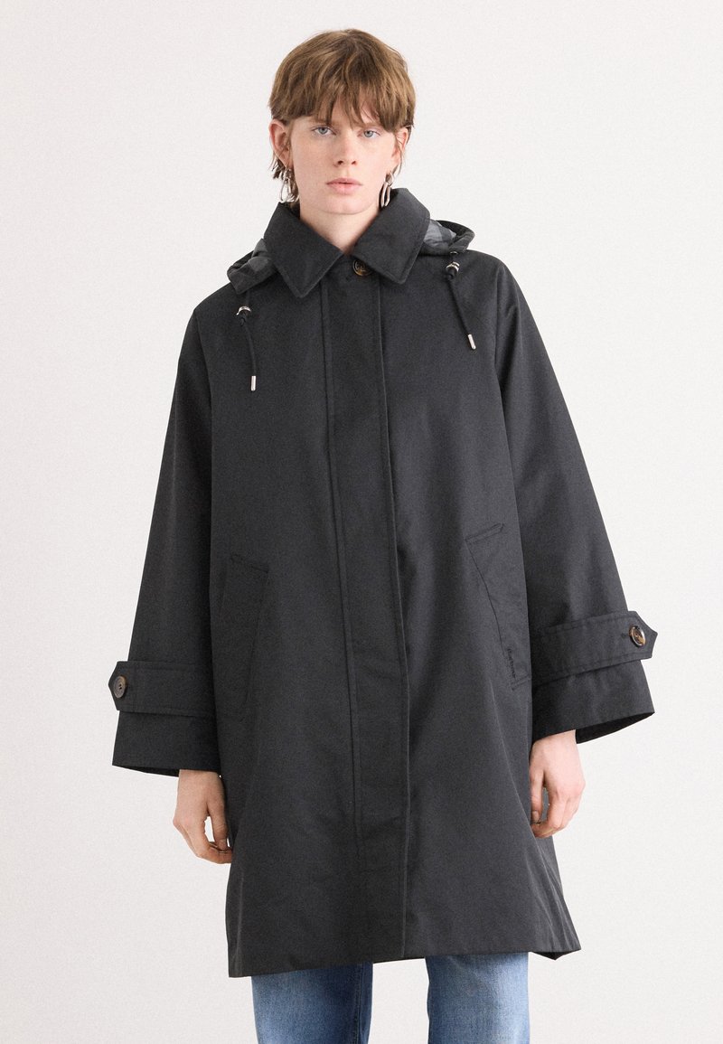Black raincoat with a high collar, drawstring hood, and large pockets. The design features wide sleeves and button accents on the cuffs.