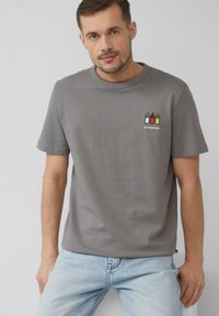 Szara bawełniana koszulka z krótkim rękawem i okrągłym dekoltem, z małym haftowanym wzorem przedstawiającym trzy butelki przypraw i napis.