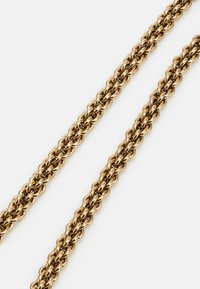 Gold-colored chain necklace with an intricate woven design. Smooth, rounded links create a textured appearance and flexible shape.