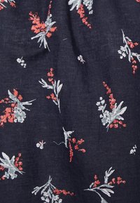 Marineblauer Stoff mit floralem Muster, das weiße und rote Blumen sowie grüne Blätter zeigt. Er bietet eine weiche Textur und dekorative Details.