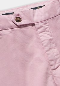 Tessuto rosa chiaro con una texture liscia, chiusura frontale a bottoni e un dettaglio di cucitura in vita. Design di pantaloni casual.