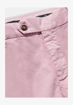 Tessuto rosa chiaro con una texture liscia, chiusura frontale a bottoni e un dettaglio di cucitura in vita. Design di pantaloni casual.