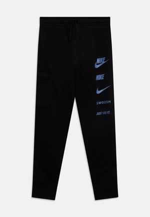 Pantalones de chándal negros hechos de material suave, con cintura ajustable con cordón, bolsillos laterales y logotipos y texto de Nike en azul impresos en el lateral.