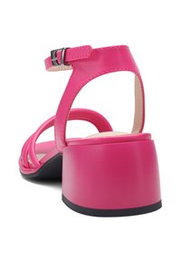 Lyserød hælet sandal med en chunky blokhæl og krydstrapdesignet. Har en justerbar ankelspænde og glat overflade.