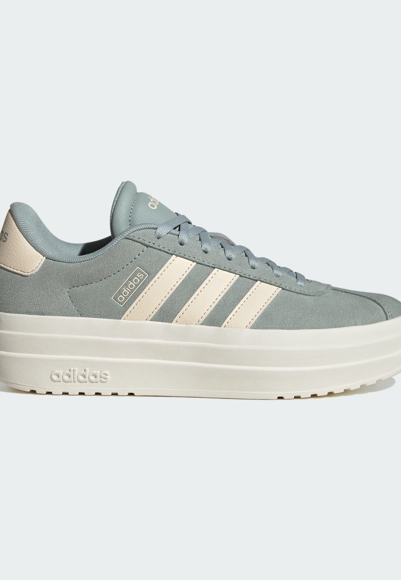 Light gray suede sneakers with a thick white midsole. Features three white stripes and "adidas" branding on the side and heel.