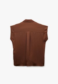 Brązowa bluzka bez rękawów z szerokimi wycięciami na ramionach i detalem plisy na plecach, ułożona płasko na białym tle.