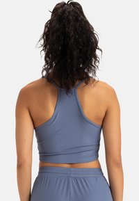 Top corto de canalé azul claro con diseño de espalda nadadora. Textura suave y forma ajustada, combinado con una parte inferior de cintura alta a juego.