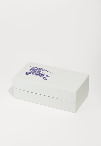 Biely obdĺžnikový box s pántovým vekom, na vrchu s podrobnou fialovou ilustráciou rytiera na koňovi.