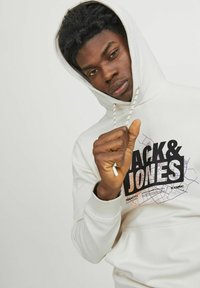 Hvid hættetrøje med en iøjnefaldende "Jack & Jones" grafik i sort og lilla, med snore og ribbede manchetter.