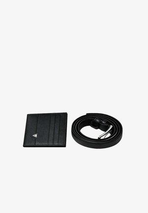 Portafoglio in pelle nera con fessure verticali per tessere e logo argentato, abbinato a una cintura in pelle nera con fibbia in metallo e finitura liscia.
