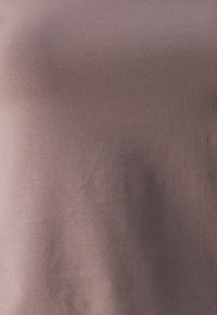 Mīksts, viegls audums izplūdušā purpura krāsā ar gludu tekstūru. Materiālam ir neliela stiepjamas īpašības un smalka spīdums.