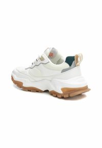 Zapatilla blanca con parte superior de malla y sintético, cuello acolchado, detalles en gris y verde, y suela de goma. Presenta cuatro ojales y detalle del logo.