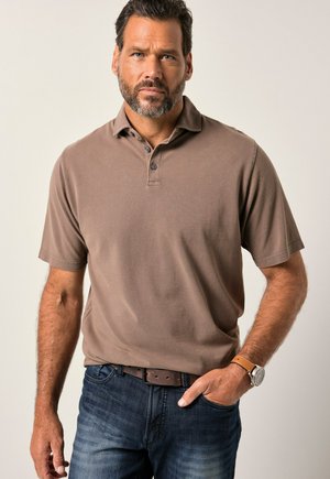 Braunes kurzärmliges Poloshirt mit Kragen, Knopfleiste und strukturiertem Stoff, kombiniert mit einer dunklen Jeans und einem braunen Ledergürtel.