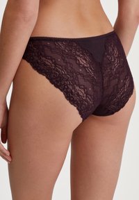 Lace-back slipjes in donkerpaars met bloemenpatronen, voorzien van een zachte katoenbasis en een gegolfde rand voor een gladde afwerking.