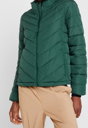 Grøn puffjakke med høj krave, med et chevron-quiltet design og en lynlås foran. Lavet af let, isoleret stof.