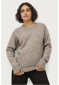 Maglione lavorato a maglia di colore marrone chiaro con maniche raglan lunghe, polsini e orlo a coste. Tessuto morbido, collo a giro e vestibilità rilassata.