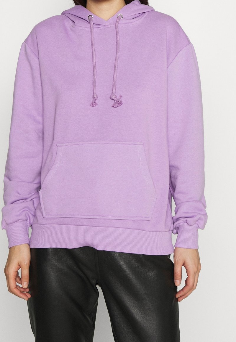 Lavendelfarbener Hoodie mit Kordeln, einer vorderen Tasche, gerippten Bündchen und Saum. Das Material wirkt weich und strukturiert und ist für die Freizeit gedacht.
