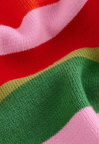 Tissu en tricot rayé aux couleurs vives : rouge, rose, vert et or. La texture est douce et extensible, avec une finition lisse et des bords côtelés.