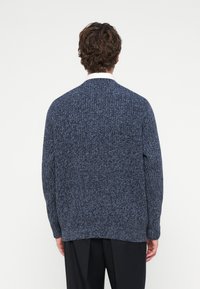 Tumši zils tamborēts džemperis ar teksturētu rakstu, apaļu izgriezumu un nogāztām plecu līnijām, garums līdz gurniem.