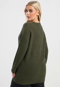 Olivgrüner Strickpullover mit lockerer Passform, ribbeliger Textur, langen Ärmeln und rundem Ausschnitt. Geeignet für die Freizeit.