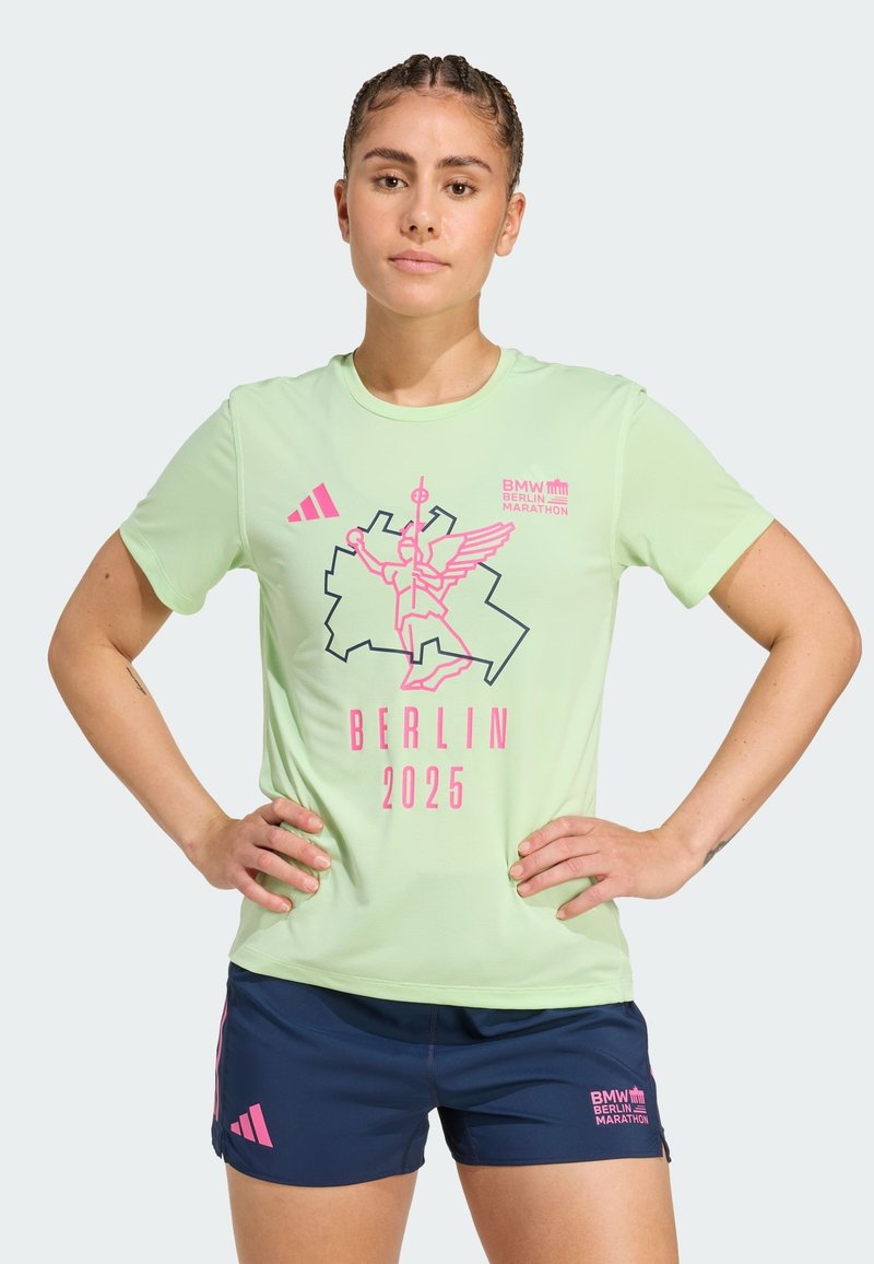 Vaalean vihreä urheilupaita, jossa on vaaleanpunainen ja musta graafinen printti; mukana teksti ja logo "Berliinin maraton 2025". Yhdistetty tummansinisiin shortseihin.