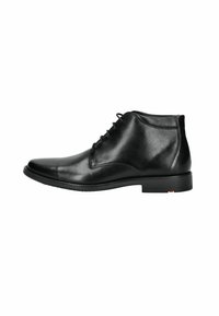 Botín de cuero negro con acabado pulido, puntera redonda y diseño con cordones. Cuenta con un tacón bajo y plano, y detalles de costura sutiles.