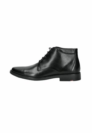 Botín de cuero negro con acabado pulido, puntera redonda y diseño con cordones. Cuenta con un tacón bajo y plano, y detalles de costura sutiles.