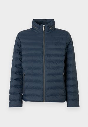 Tamsiai mėlyna siuvinėta pūkinė striukė su priekiu užtrauktuku, aukštu apykakle, užtrauktukais šonuose ir subtiliu „ck“ logotipu ant krūtinės.