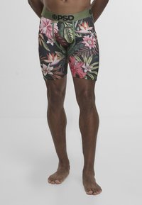 Bokserki męskie z kwiatowym nadrukiem przedstawiającym różowe i białe kwiaty na czarnym tle. Elastyczny pas w kolorze oliwkowej zieleni. Tkanina rozciągliwa.