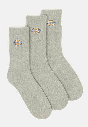 Drei Paare von hellgrauen Baumwollsocken mit ribbeliger Textur und einem kreisförmigen blauen und orangen Dickies-Logo auf der Oberseite.