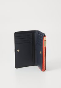 Navy leather wallet with orange zipper, featuring multiple card slots and a snap closure. Smooth texture and minimalist interior design.