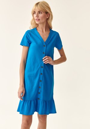 Robe en coton bleu avec un décolleté en V, des manches courtes et un ourlet volé. Présente des boutons à l'avant et une coupe décontractée.