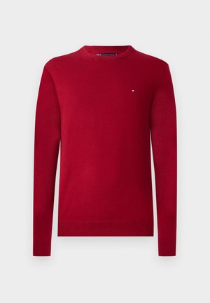 Rode, lange mouwen trui gemaakt van zacht materiaal met een ronde hals. Kenmerkt zich door een klein logo op de borst en geribde manchetten en zoom.