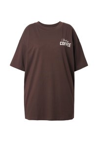 Brun oversized bomulds-t-shirt med korte ærmer, der har hvid tekst "Friday COFFEE" på fronten. Enkel design, afslappet pasform.