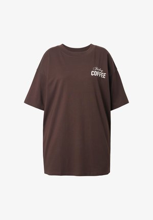 Bruine oversized katoenen t-shirt met korte mouwen, met daarop witte tekst "Friday COFFEE" aan de voorkant. Eenvoudig ontwerp, ontspannen pasvorm.