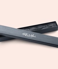Scatola per gioielli nera con una finitura testurizzata, con il logo "Sofia Milani Jewels" in bianco. Il coperchio aperto rivela un interno nero.