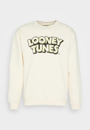 Cremefarbener Sweatshirt mit langen Ärmeln, auf der Brust mit fett gedrucktem „Looney Tunes“-Schriftzug in Schwarz und Gelb.