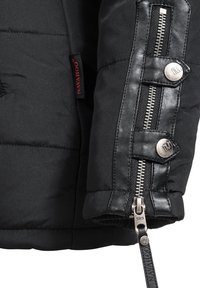 Rękaw czarnej kurtki puchowej z pikowanym wzorem, skórzanymi elementami, srebrnym zamkiem błyskawicznym oraz oznaczoną metką, podkreślający kontrast materiałów i detale.