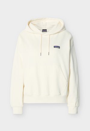 Hanorac Patagonia de culoare alb-murdar cu buzunar frontal, glugă cu șnur, manșete ribbed și o mică etichetă cu logo pe piept.