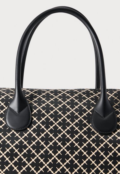 Τσάντα χειρός με μοτίβο σε μαύρο και μπεζ χρώμα, με υφή στην επιφάνεια, δύο λείες μαύρες λαβές και διακριτικές λεπτομέρειες ραφής.